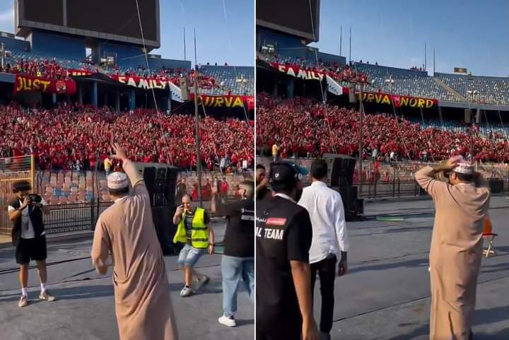 المعلق خليل البلوشي يقدم التحية لجماهير الأهلي أثناء تواجده في ملعب المباراة