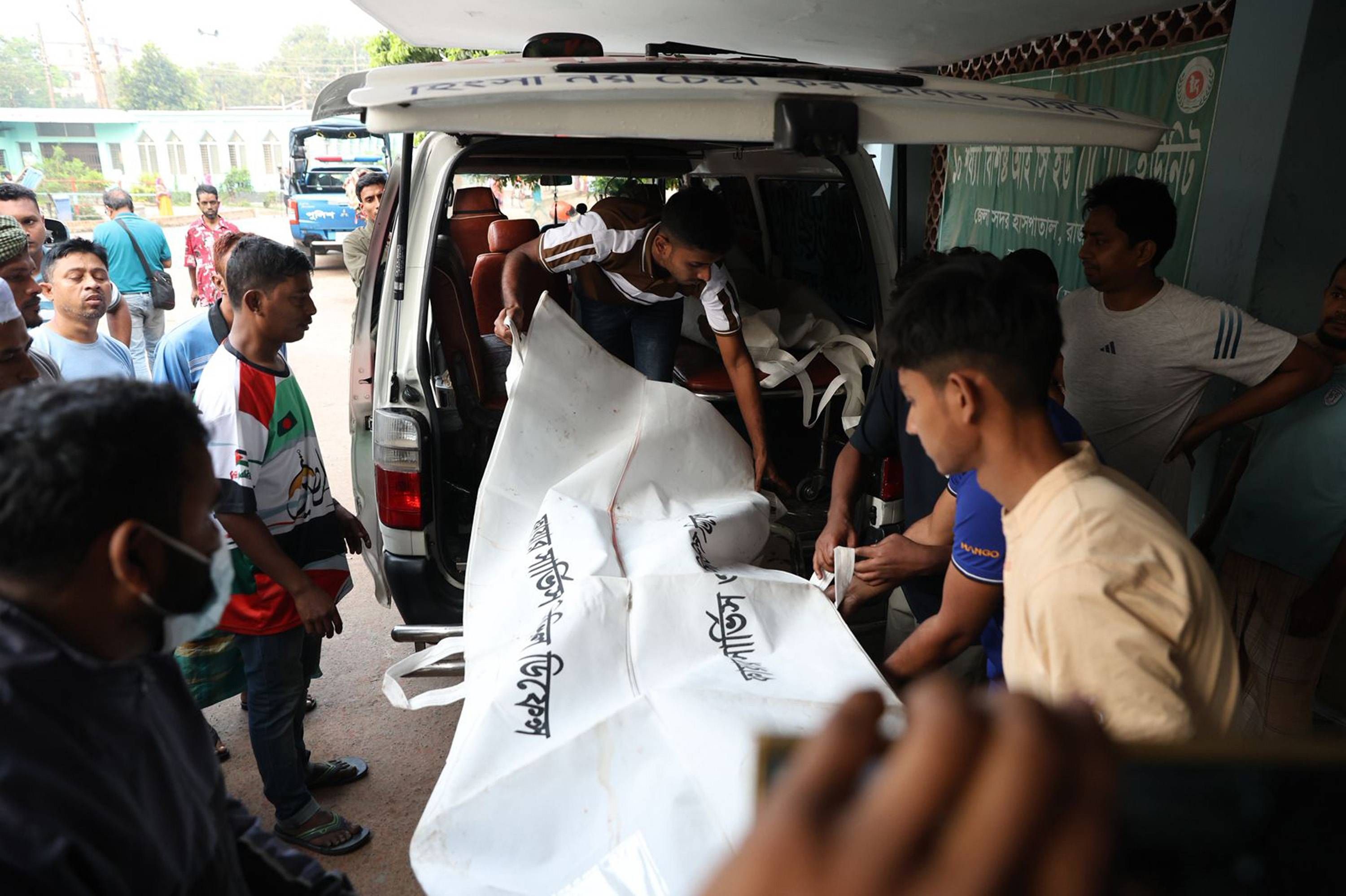 جثث ضحايا حادث الحافلة خلال نقلها إلى مستشفى راجباري الحكومي في العاصمة دكا (إ.ب.أ)